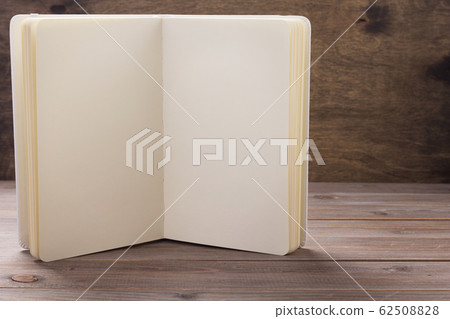 notepad or paper book at wooden table notepad or paper book at wooden table 62508828
