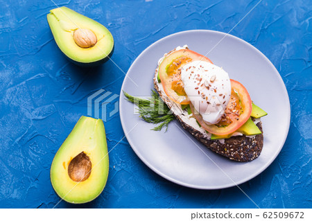 Sandwich with smoked salmon, egg and avocado on blue background, top view. Concept for healthy nutrition. Sandwich with smoked salmon, egg and avocado on blue background, top view. Concept for healthy nutrition. 62509672