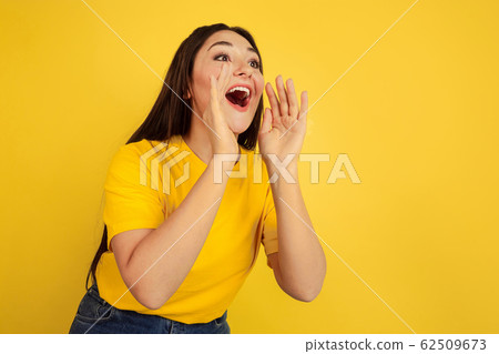 Caucasian woman's portrait isolated on yellow studio background Caucasian woman's portrait isolated on yellow studio background 62509673