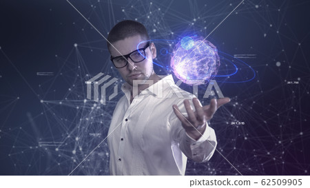 A male scientist in a white shirt holds an abstract ball in his hands against a background of plexus 62509905