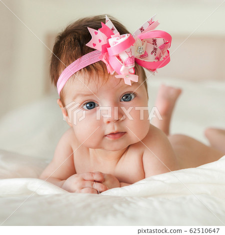 Newborn child relaxing in bed. 62510647