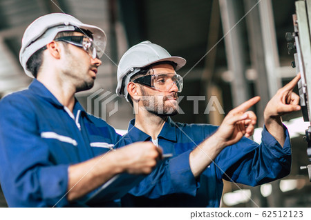 engineer teamwork checking control panel and teaching new worker to operating control 62512123