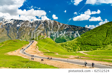 Tourists walking towards Gergeti Trinity Church under Mount Kazbegi in Georgia 62512524