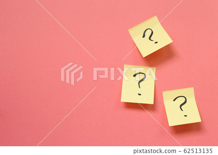 Question mark on memo paper on pink background. Solution concept 62513135