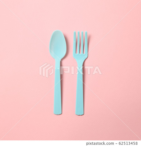 Blue plastic fork and spoon isolated on pink background 62513458