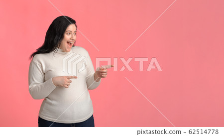 Surprised Plump Woman Pointing Aside At Copy Space On Pink Background Surprised Plump Woman Pointing Aside At Copy Space On Pink Background 62514778