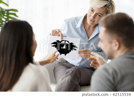 Psychotherapist Testing Spouses Showing Inkblot Picture Sitting In Office Psychotherapist Testing Spouses Showing Inkblot Picture Sitting In Office 62515539