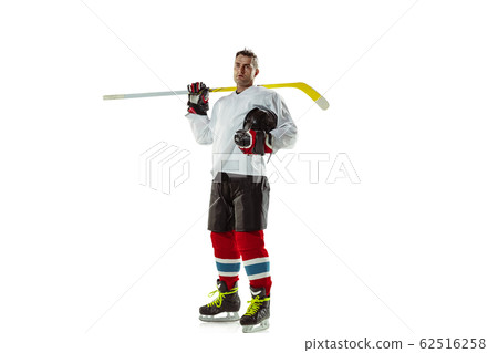Young male hockey player with the stick on ice court and white background 62516258