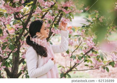 brunette woman enjoying spring day in park 62516899