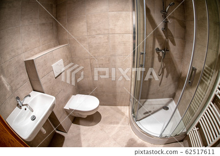 Mounted toilet bowl, sink and shower in hotel room Mounted toilet bowl, sink and shower in hotel room 62517611
