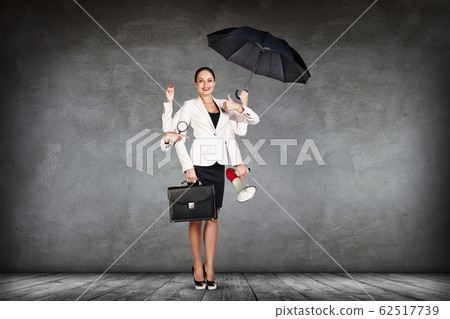 Young business woman multitasking with different staff in hands. Young business woman multitasking with different staff in hands. 62517739