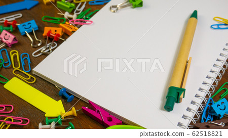 Paper notebook and stationery on wooden brown desk Paper notebook and stationery on wooden brown desk 62518821
