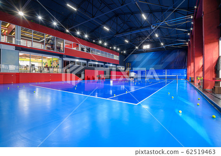 Blue colored empty indoor tennis court 62519463