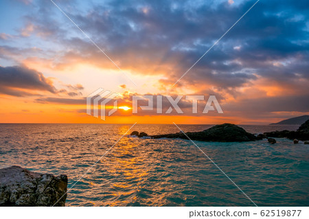 Sea Dawn and Sun Rays on the Rocky Shore Sea Dawn and Sun Rays on the Rocky Shore 62519877