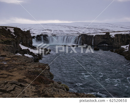 Snowy mountains at Godafoss Waterfall in Iceland Snowy mountains at Godafoss Waterfall in Iceland 62520658