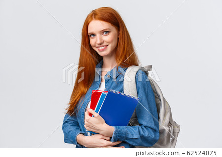 Time to school. Lovely cheerful modern redhead female with backpack holding notebooks heading college, smiling amused, heading back to class after break, standing white background 62524075