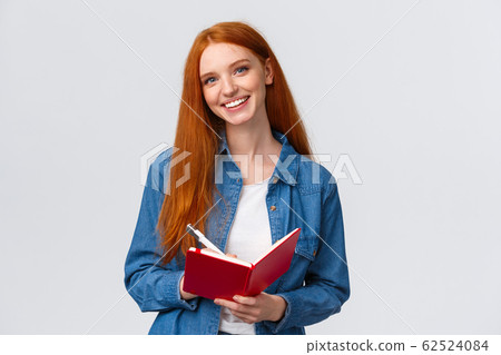 Charismatic talented cute redhead female student studying, taking notes after teacher in notebook, writing in diary, drawing doodles standing white background cheerful Charismatic talented cute redhead female student studying, taking notes after teacher in notebook, writing in diary, drawing doodles standing white background cheerful 62524084