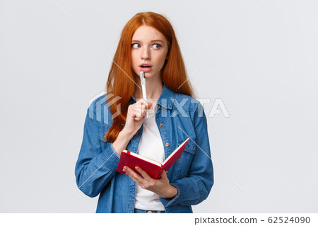 Talented, creative good-looking redhead woman writing poem, story, taking notes, prepare grocery list, gasping recall, remember something writing-down in notebook, white background 62524090