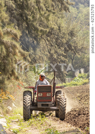 Man preparing the land for harvest with the 62525793
