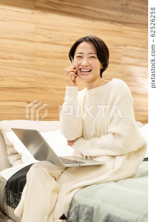 Middle woman bedroom smartphone personal computer lifestyle image Middle woman bedroom smartphone personal computer lifestyle image 62526258