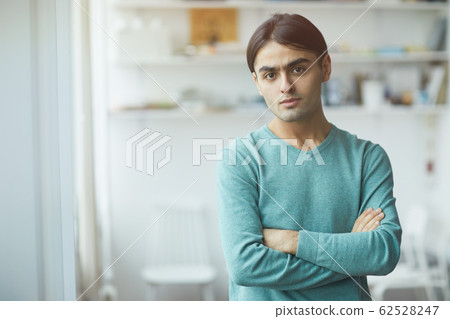 Young man standing at office Young man standing at office 62528247