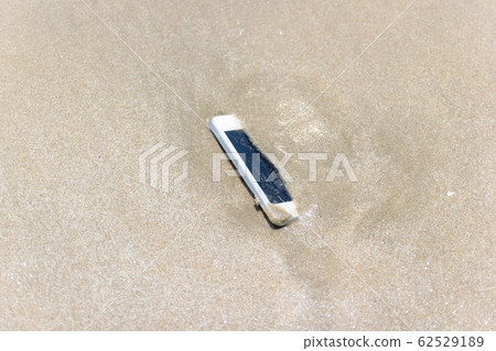 Mobile phone floated to the sea at the beach. 62529189