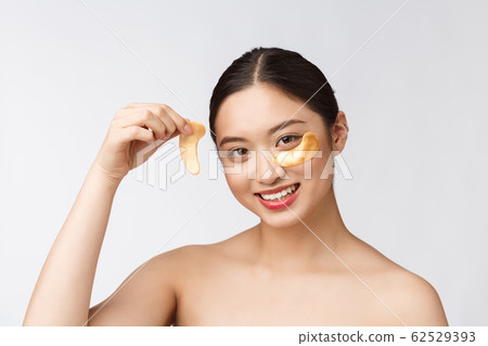Asian beauty teenager woman care her skin with gold eye masks patches under eyes Asian beauty teenager woman care her skin with gold eye masks patches under eyes 62529393