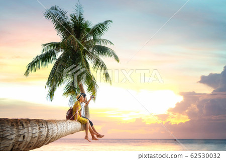 Asian couple sit on coconut tree 62530032