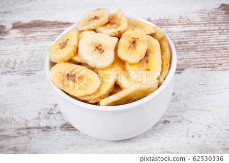 Banana chips in bowl as natural snack for dessert Banana chips in bowl as natural snack for dessert 62530336