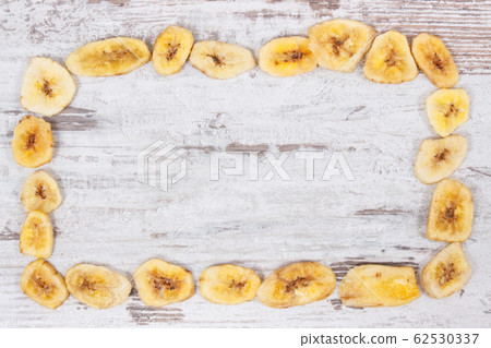 Frame of dried banana chips as natural snack 62530337