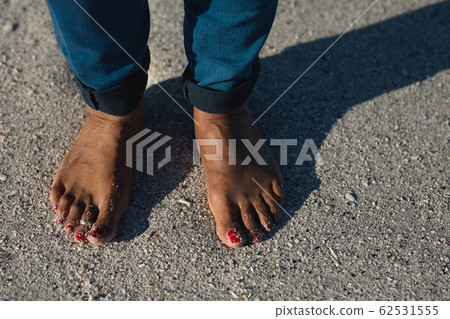 Senior woman standing on the beach bare feet Senior woman standing on the beach bare feet 62531555
