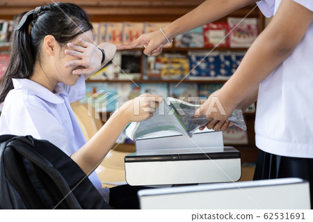 Asian child girl who has been bullied by her friends, snatched the book out of her hand,girl student reading a book will prepare for the exam,schoolgirl crying because of bullying at school library Asian child girl who has been bullied by her friends, snatched the book out of her hand,girl student reading a book will prepare for the exam,schoolgirl crying because of bullying at school library 62531691