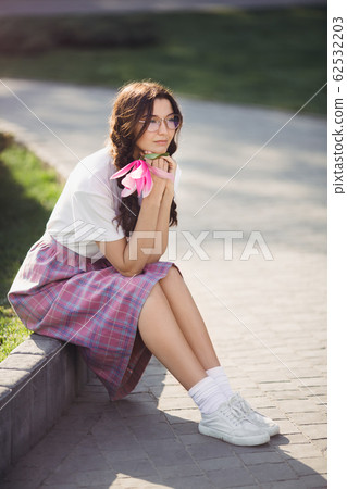 Woman with Flower Outdoors in the City Park Woman with Flower Outdoors in the City Park 62532203