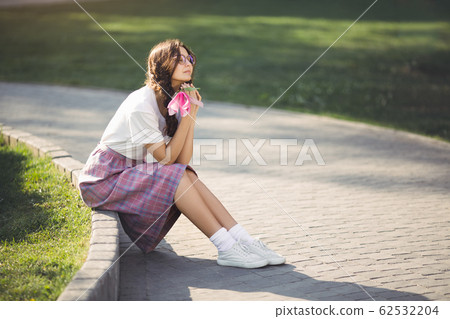 Woman with Flower Outdoors in the City Park Woman with Flower Outdoors in the City Park 62532204