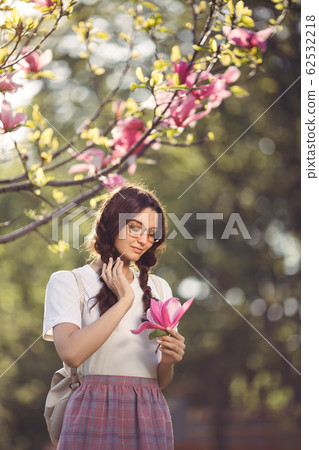 Woman with Flower Outdoors in the City Park 62532218