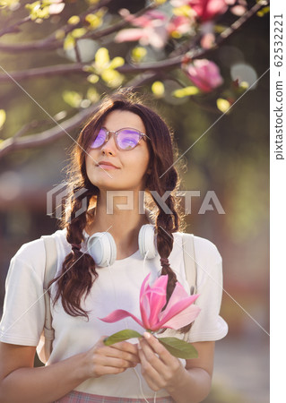 Woman with Flower Outdoors in the City Park Woman with Flower Outdoors in the City Park 62532221