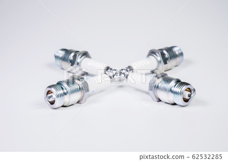 Subject shooting on a gray background. new four spark plugs, spare parts for a gasoline engine. The concept of new auto parts and maintenance Subject shooting on a gray background. new four spark plugs, spare parts for a gasoline engine. The concept of new auto parts and maintenance 62532285