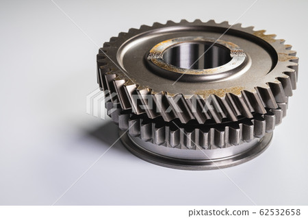 New parts on a gray background. Gears of gear shifting torque transmission. Conceptually mechanical background. Shiny gear box gear teeth 62532658