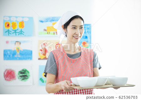 Nursery teacher carrying school lunch 62536703