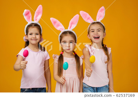 child girls holding painted Easter eggs 62537169