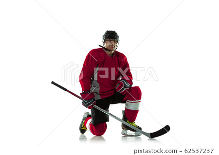 Male hockey player with the stick on ice court and white background Male hockey player with the stick on ice court and white background 62537237