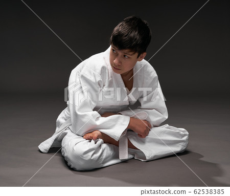 a teenager dressed in martial arts clothing poses a teenager dressed in martial arts clothing poses 62538385