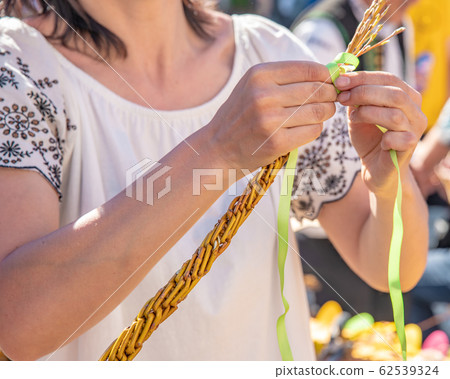 a woman knitting his Easter whip from a rod 62539324