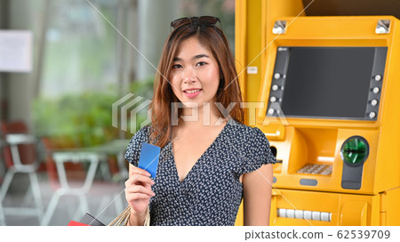 Young beautiful girl in dress holding a credit card and shopping bags. Young beautiful girl in dress holding a credit card and shopping bags. 62539709