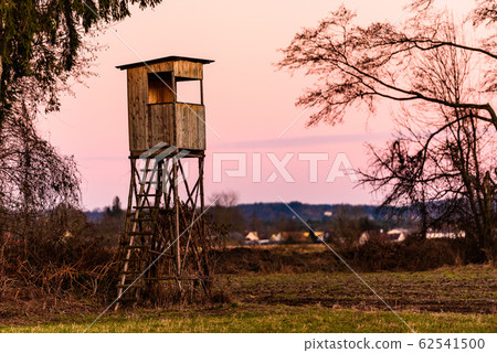 Hunting tower after sunset in rural scenery against pink sky. Deer stand near Zettling Graz in Austria. Hunting tower after sunset in rural scenery against pink sky. Deer stand near Zettling Graz in Austria. 62541500