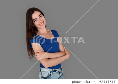 Young girl studio standing isolated on grey crossed arms looking camera playful Young girl studio standing isolated on grey crossed arms looking camera playful 62541731