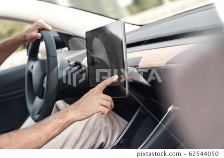 Young adult man adjusting interface system in car Young adult man adjusting interface system in car 62544050