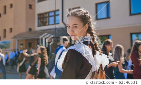 Happy Russian girl graduate with pigtails on the day of graduation. 62546531