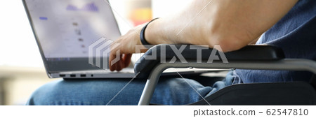 Man sitting in wheelchair working with laptop computer Man sitting in wheelchair working with laptop computer 62547810