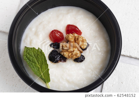 Rice milk porridge with raisin, nut and mint leaf Rice milk porridge with raisin, nut and mint leaf 62548152